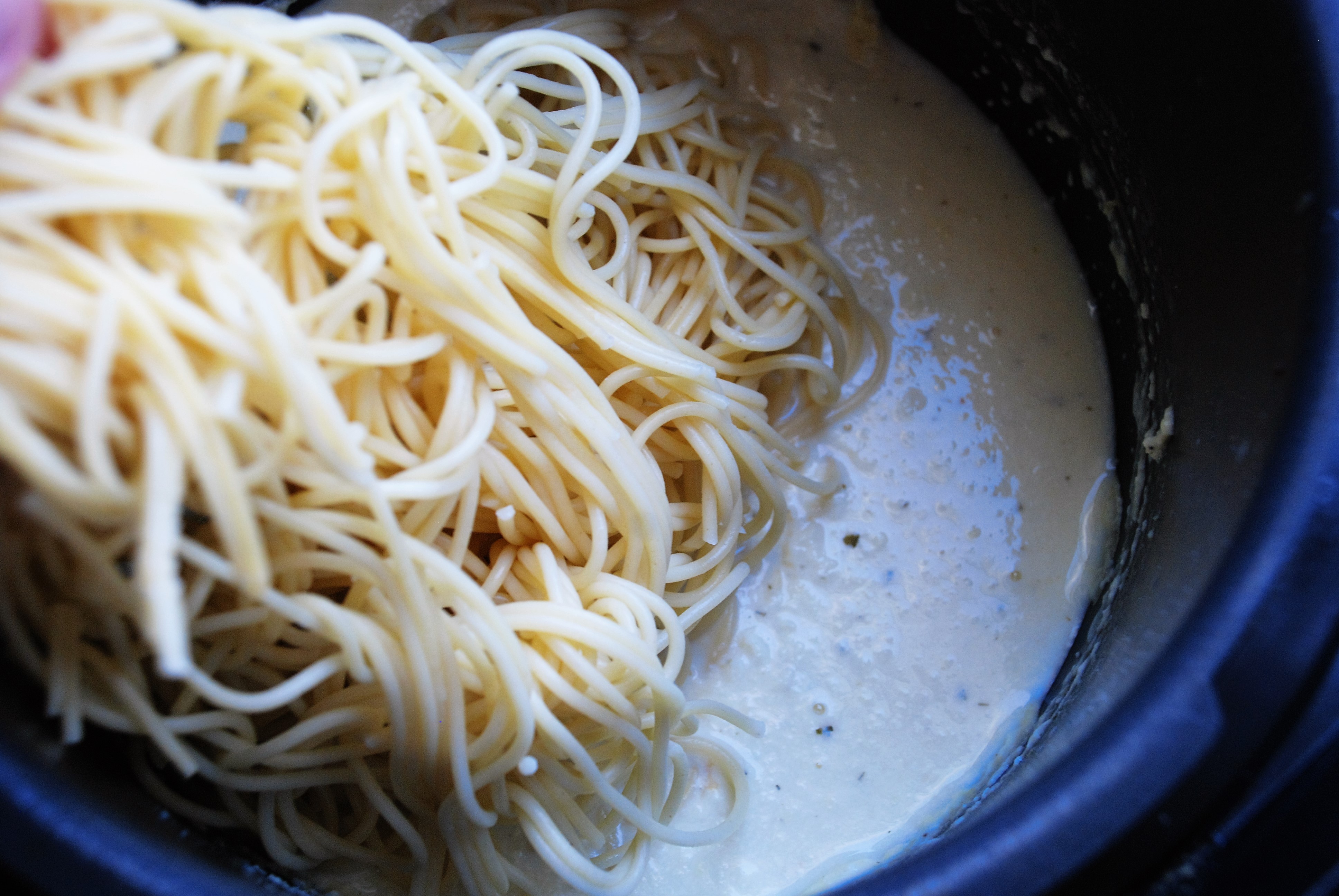 Щипцами переложите спагетти в мультиварку с соусом, перемешайте. Соус станет густым в сочетании со спагетти